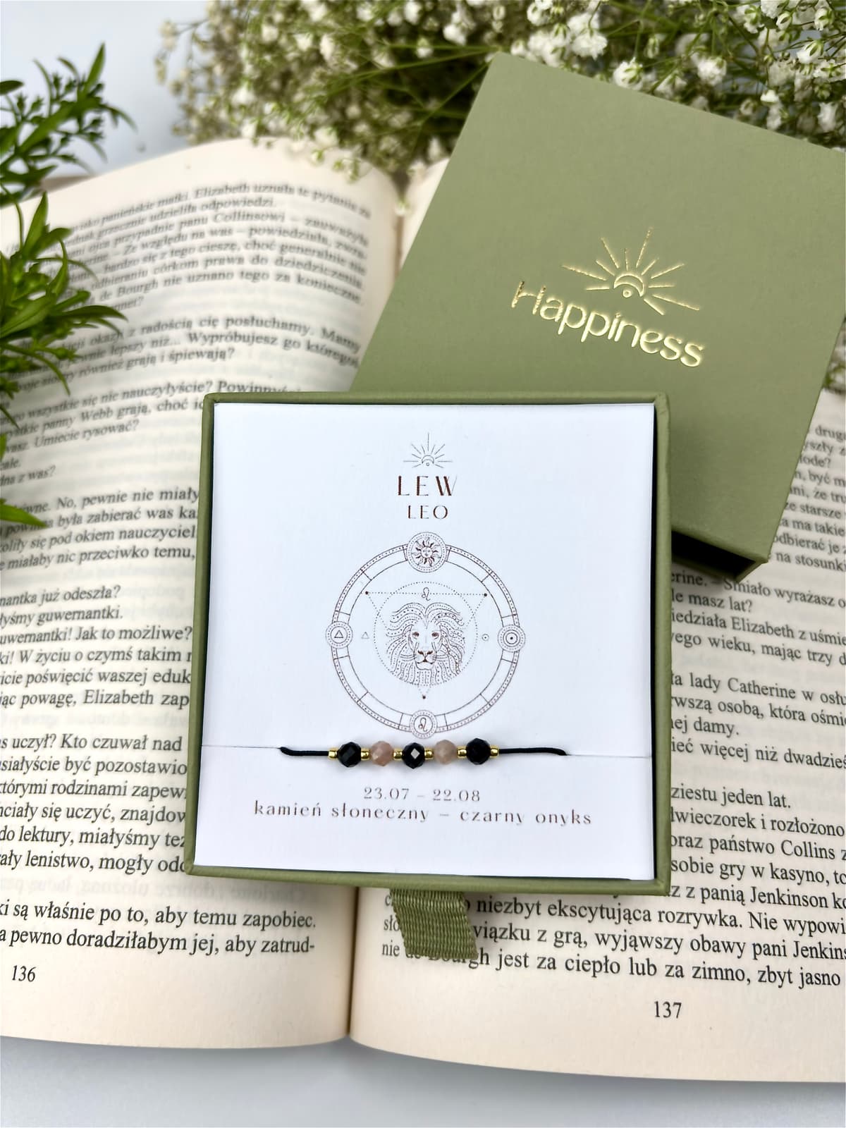 Bransoletka na czarnym sznurku nylonowym z koralikami z kamieni naturalnych: beżowym kamieniem słonecznym i czarnym onyksem. Opakowana w pudełko w kolorze oliwkowym ze złotym logo Happiness.