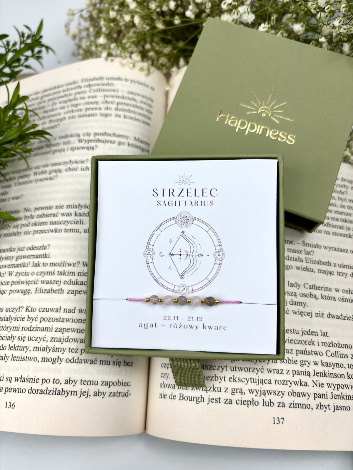 Bransoletka na różowym sznurku nylonowym z koralikami z kamieni naturalnych: szarym agatem i różowym kwarcem. Opakowana w pudełko w kolorze oliwkowym ze złotym logo Happiness.
