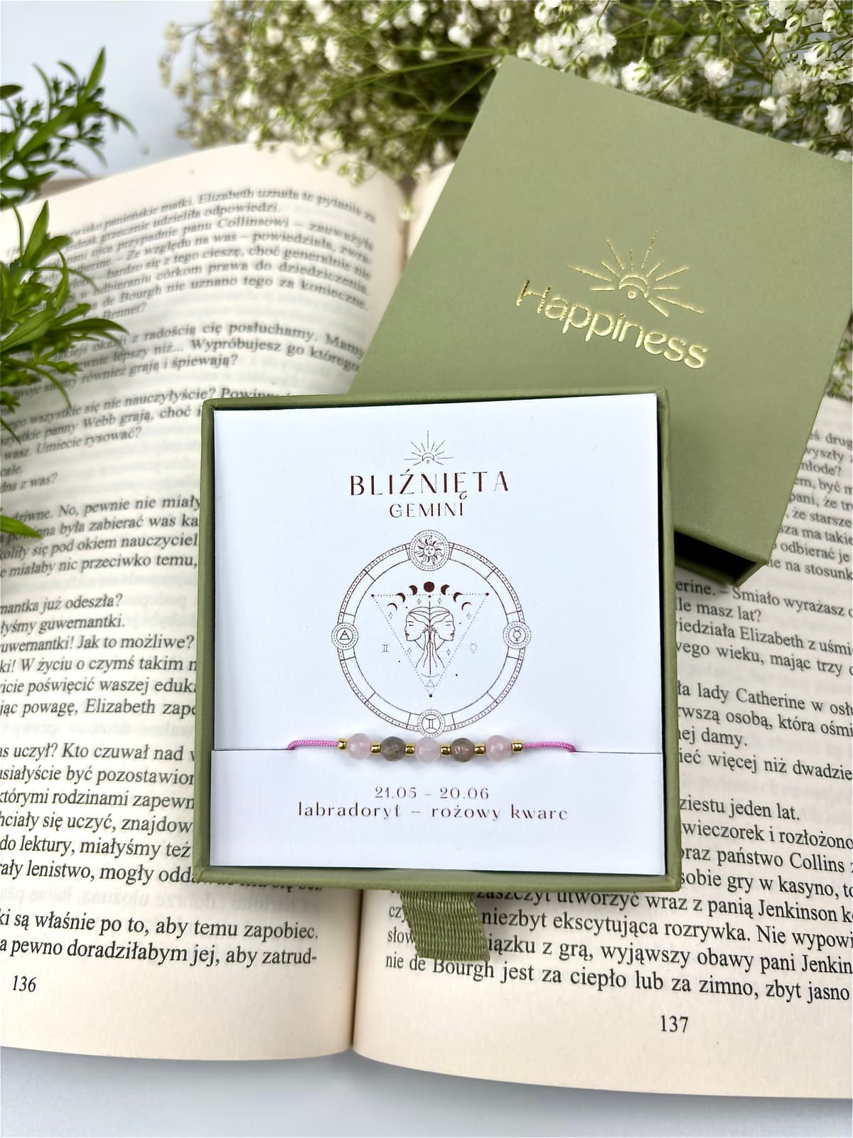 Bransoletka na różowym sznurku nylonowym z koralikami z kamieni naturalnych: szarym labradorytem i różowym kwarcem. Opakowana w pudełko w kolorze oliwkowym ze złotym logo Happiness.