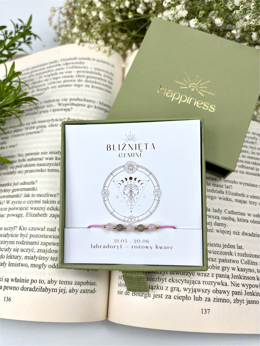 Bransoletka na różowym sznurku nylonowym z koralikami z kamieni naturalnych: szarym labradorytem i różowym kwarcem. Opakowana w pudełko w kolorze oliwkowym ze złotym logo Happiness.