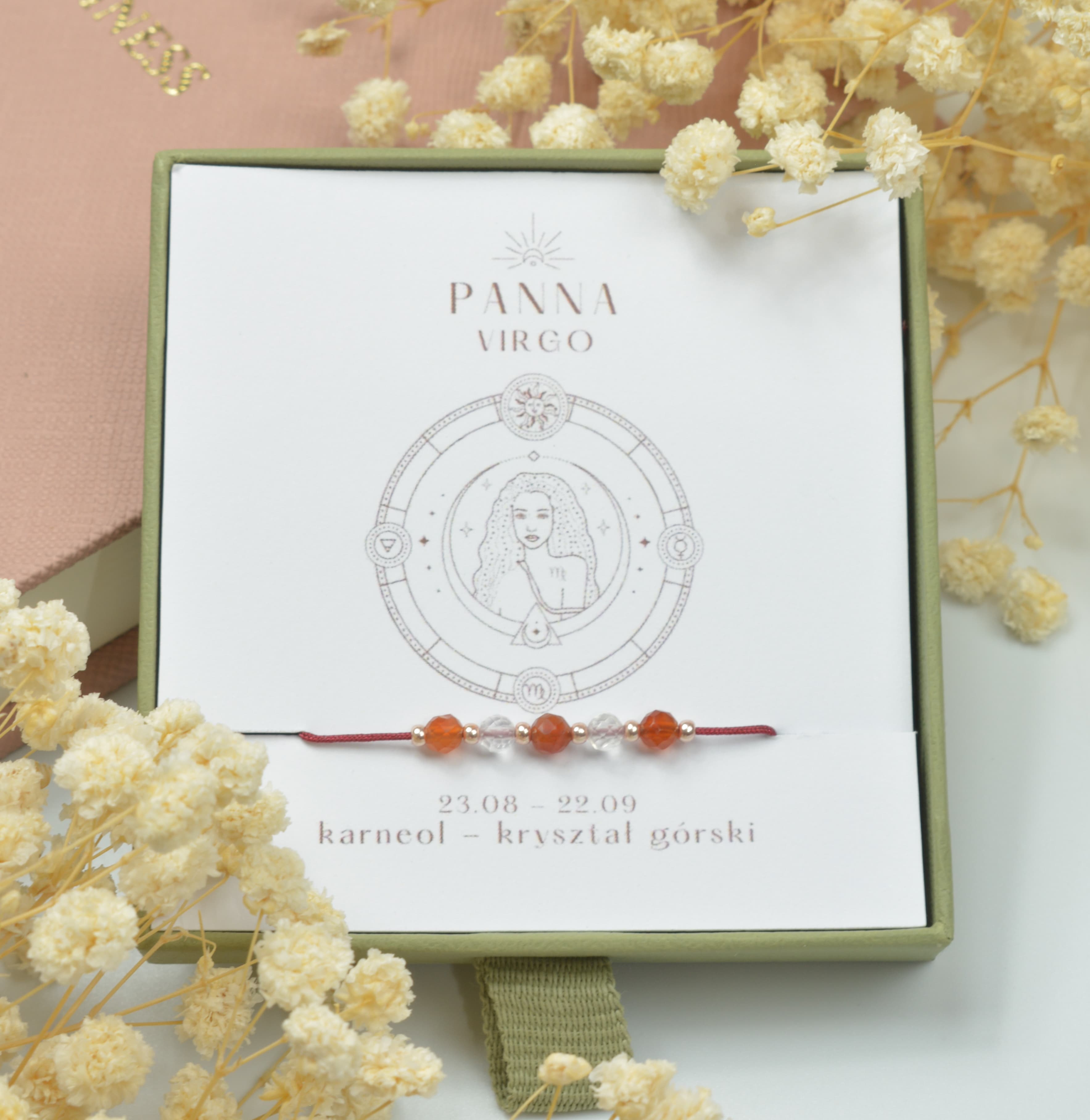 Bransoletka na czerwonym sznurku nylonowym z koralikami z kamieni naturalnych: pomarańczowym karneolem i przezroczystym kryształem górskim. Opakowana w pudełko w kolorze oliwkowym ze złotym logo Happiness.